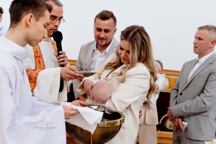 fotograf na chrzest Warszawa - dziecko z rodzicami po uroczystości
